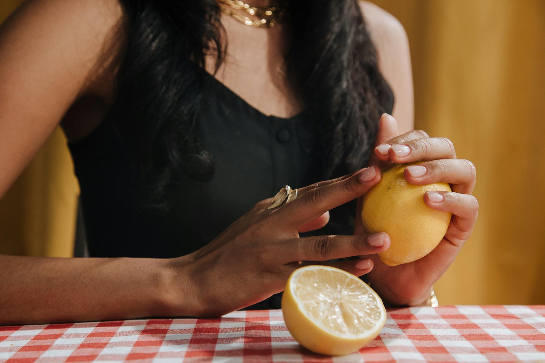 A hand holding an orange vibrator against a minimalistic purple backdrop, showcasing modern sensuality and intimate exploration.