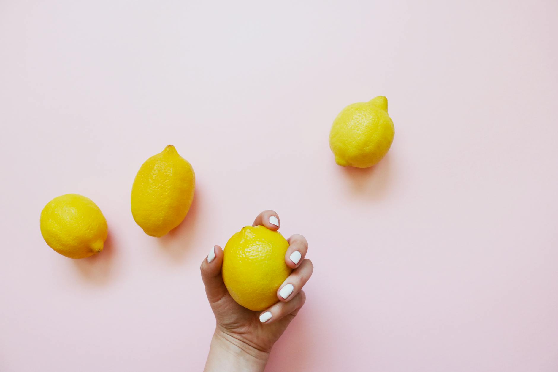 A hand holding an orange vibrator against a minimalistic purple backdrop, showcasing modern sensuality.