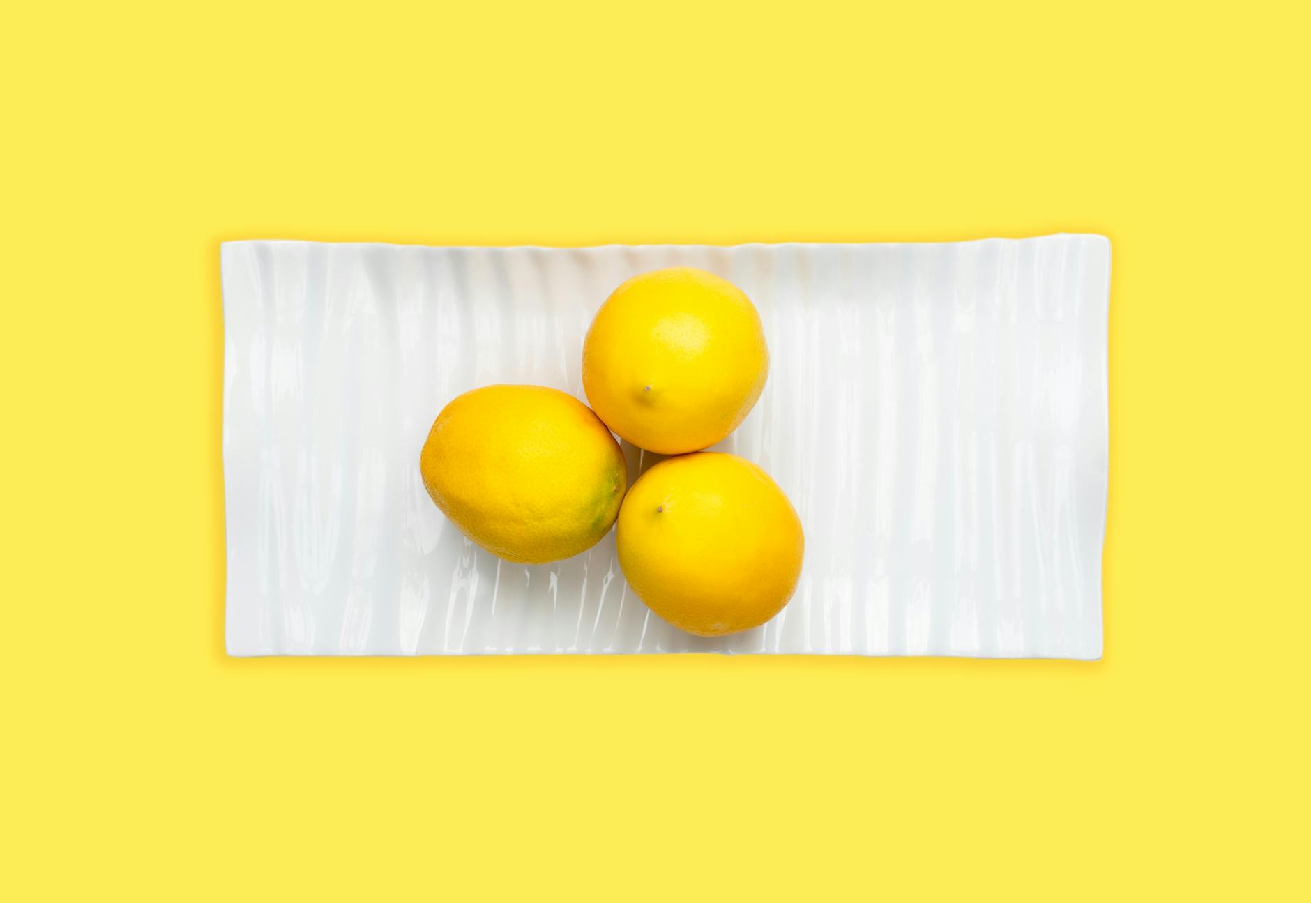 Fresh yellow lemons on pastel green background, symbolizing renewal and natural pleasure